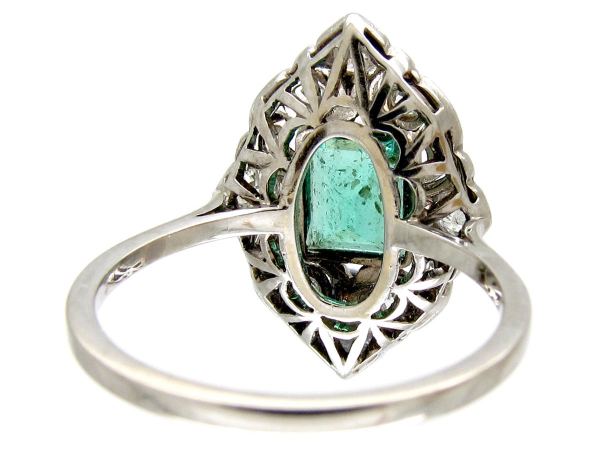 A beautifully made Art Deco ring with a platinum top and an 18ct gold shank. The rectangular Columbian emerald is a good even colour and it is complimented by diamonds. It would make a wonderful engagement ring.