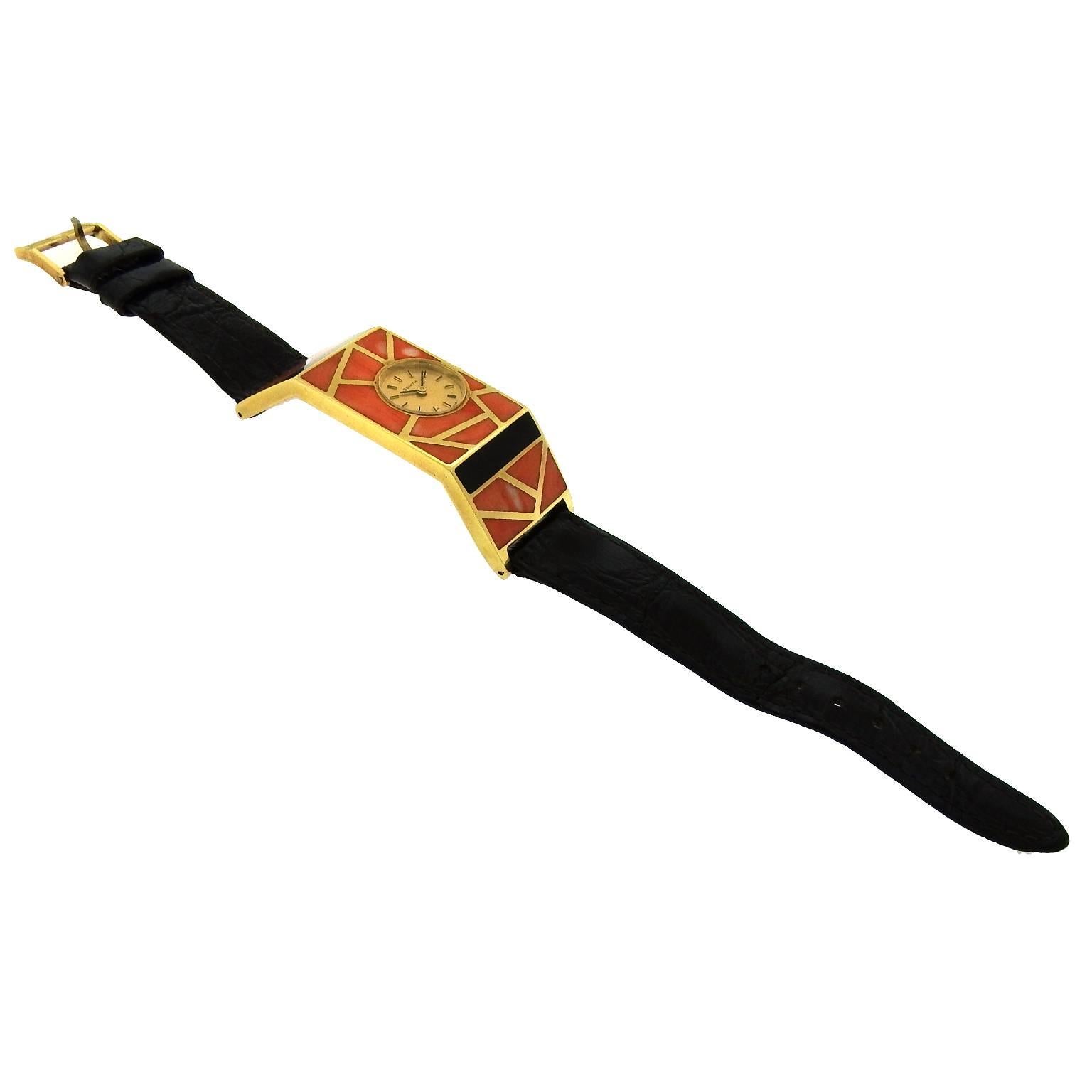 Collector's rare 1970's wristwatch, this stylized 18K yellow gold and coral mosaic watch is one-of-a-kind. The 22mm x 60mm case is an elongated rectangle with fixed hinged extended lugsinlaid with onyx bars and coral. The round champagne dial, 13mm,