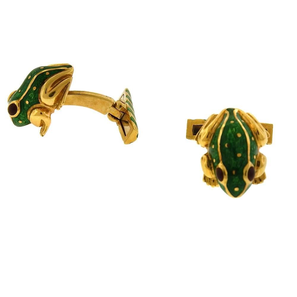 David Webb 18K yellow gold, green enamel and ruby eye cufflinks, circa 1990, measure 5/8" x 5/8" x 1" with fixed curved backs.