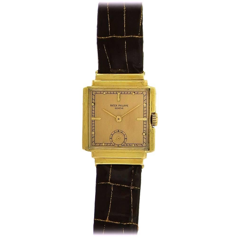 Extremely rare 18K yellow Patek Philippe tank watch made in 1941 is stylized with double stepped hooded lugs, a recessed crown, matte silvered dial with applied gold hour indexes, subsidiary seconds register, and 18 jewel manual wind movement,