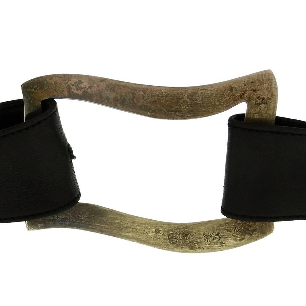 From Angela Cummings, her sterling silver sling buckle and belts, made in 1984, apparantly never worn, includes two soft leather belts, one brown and one black, to thread through the waved sterling buckle and cinch at front. The stering buckle