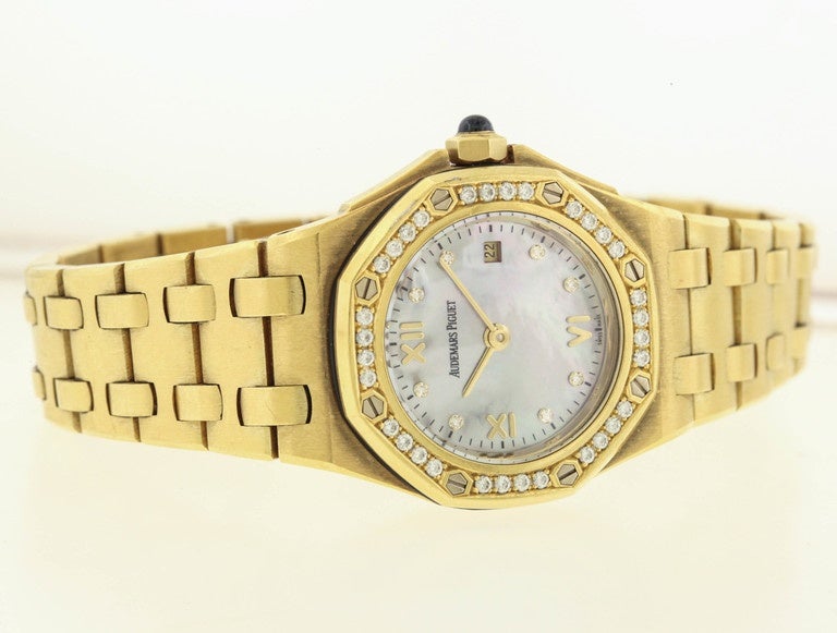 18K yellow gold and diamond Audemars Piguet Royal Oak Offshore is a women's quartz wristwatch with mother-of-pearl dial and diamond bezel.  the 29mm yellow gold case has a back secured with 8 screws, octagonal gold bezel set with 32 brilliant-cut