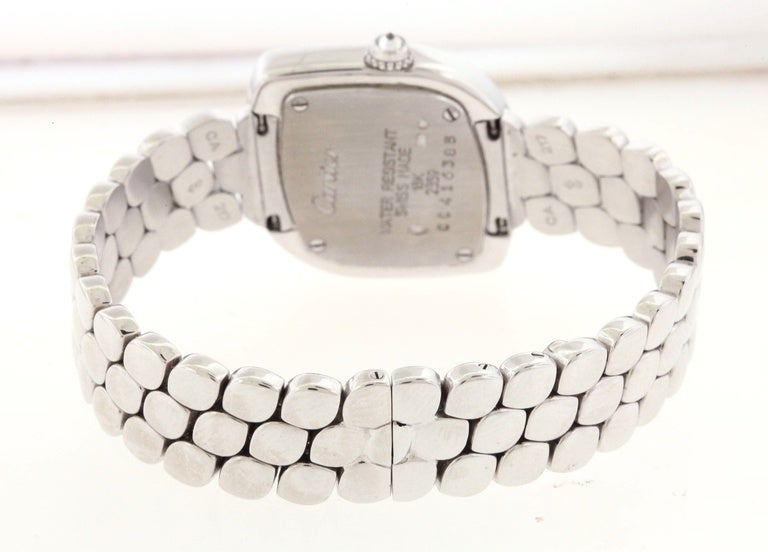 18K white gold Cartier Ref. 2359, produced in the 1990's, is an unusual, water-resistant, oblique navette-shaped, 18K white gold and diamond women's quartz wristwatch with an 18K white gold Cartier matching navette link bracelet with deployant