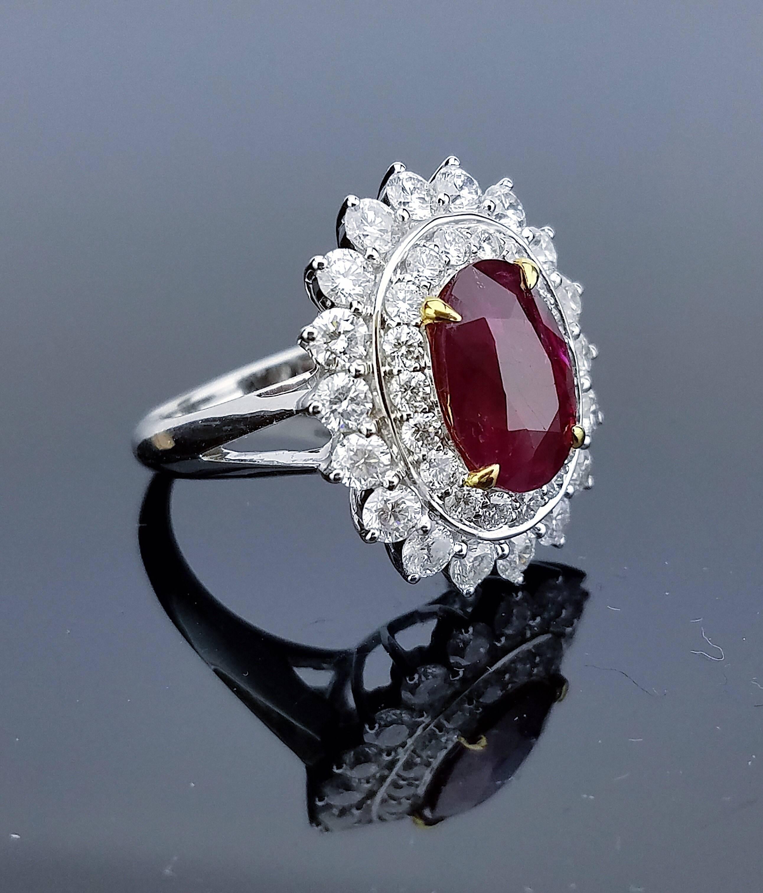 No heat Burma Ruby Ring with Yellow Gold Prongs, surrounded with Brilliant cut Diamonds all mounted on 18K White Gold hoop  

Center Stone Details:  
Stone: Burma Ruby (no heat) 
Cut: Oval 
Weight: 3.41 carat  

Diamond Details:  
Cut: Round
Total