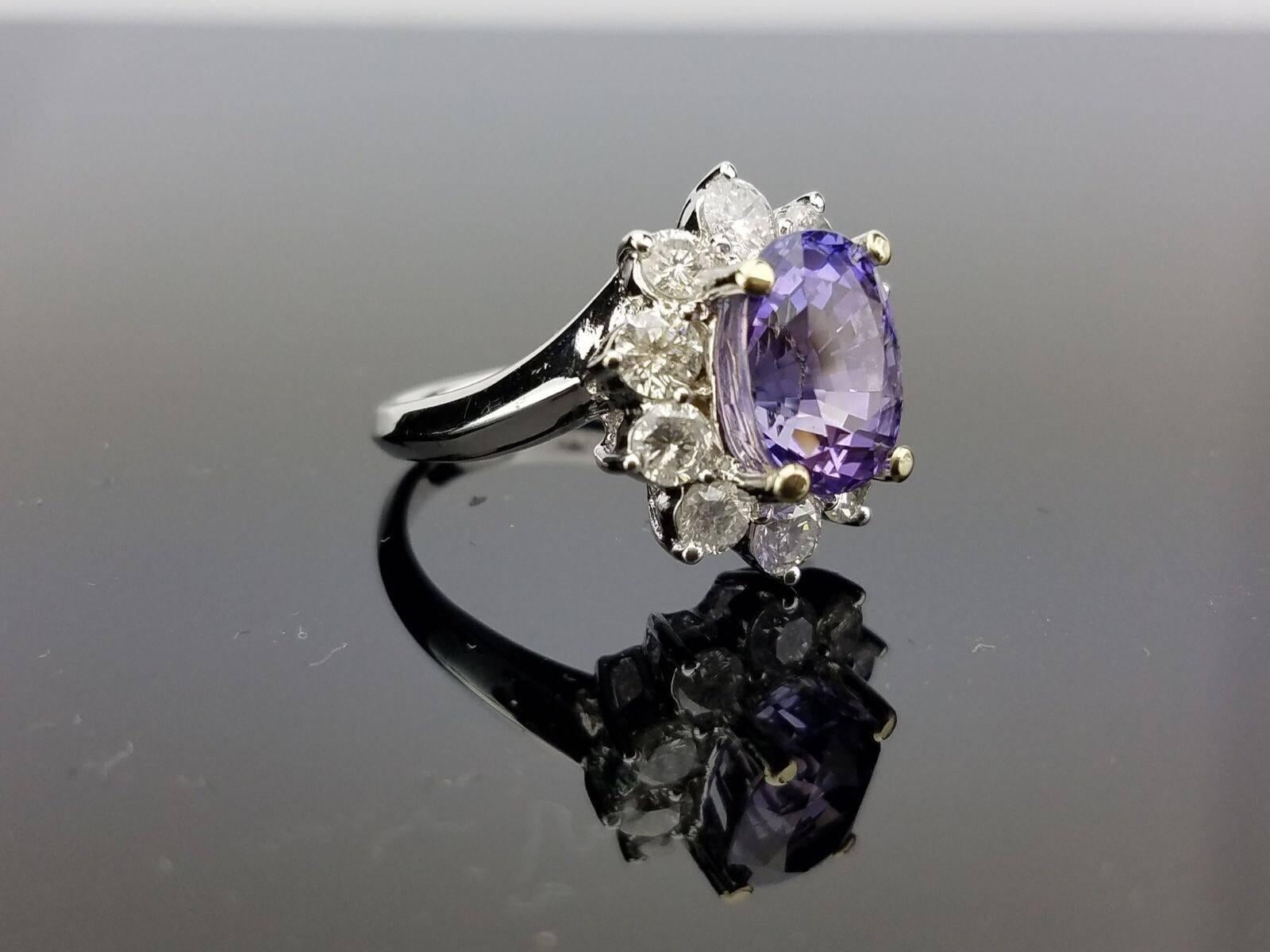 Light Purple Sapphire and Diamond Ring on 18K White Gold Band

Center Stone Details: 
Stone: Sapphire
Cut: Oval
Weight: 4.89 carat

Diamond Details: 
Cut: Brilliant (round)
Total Carat Weight: 1.3 carat
Quality: VS , H/I/J 

18K Gold: 6.61