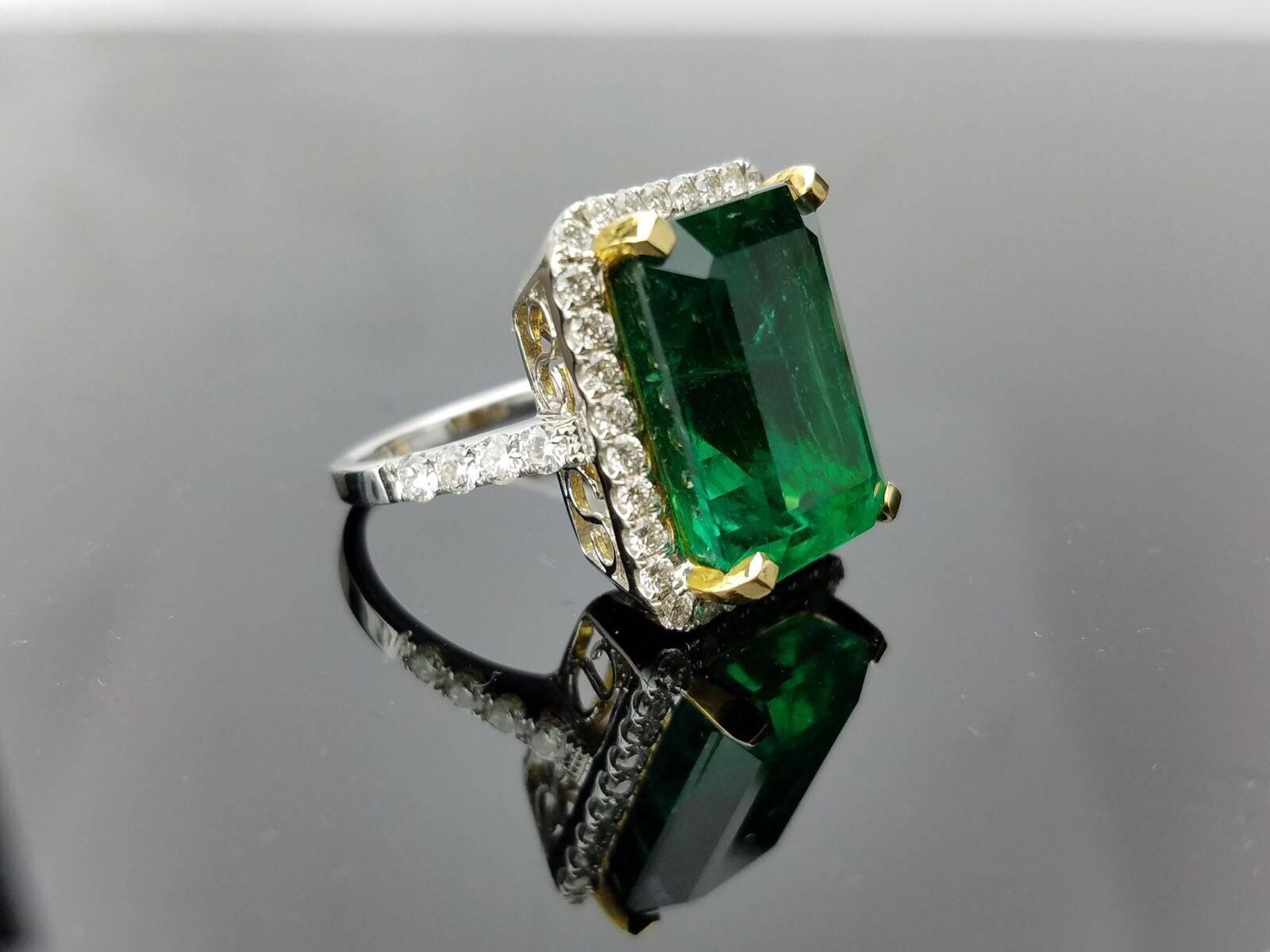 Beautiful and Lustrous, High Quality Zambian Emerald Cocktail Ring outlined with Diamond, all set in 18 White Gold and Yellow Gold prongs. 

Stone Details:  
Stone: Zambian Emerald
Cut: Emerald Cut
Carat Weight: 15.19 carat

Diamond Details:
Cut: