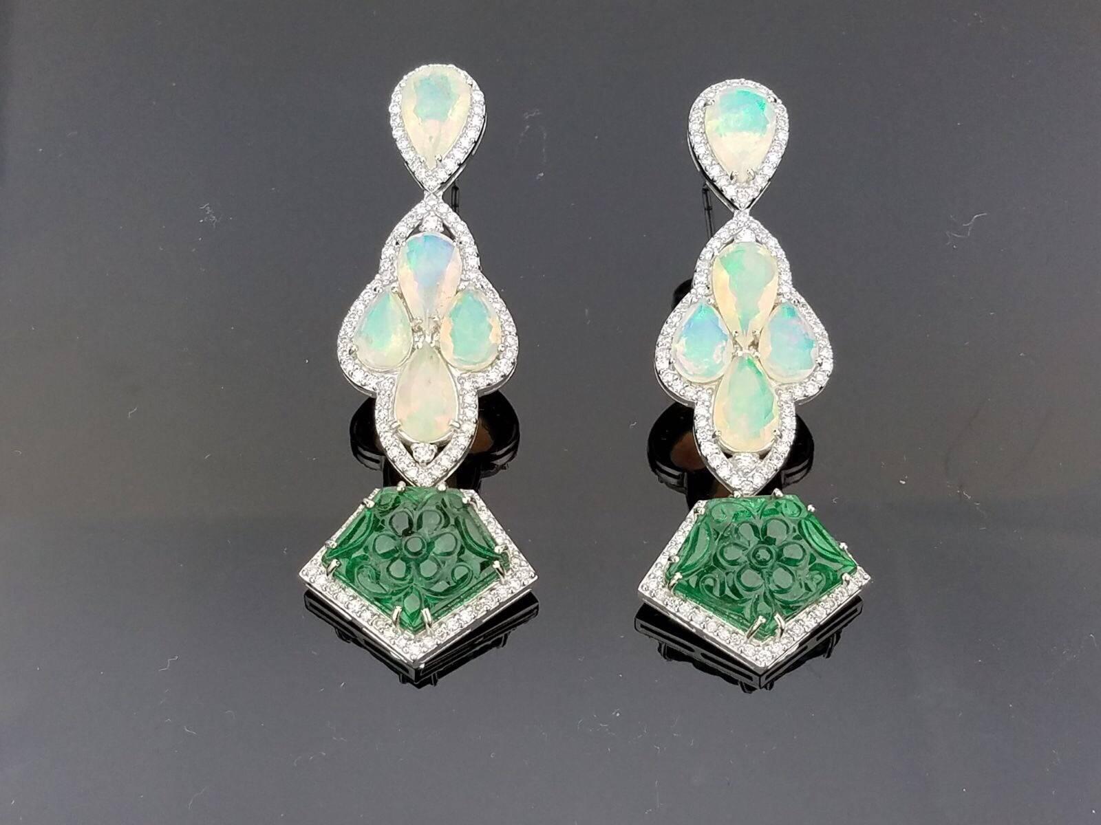 Unique Dangling Earrings, with Ethiopian Opals, Zambian Emeralds - outlined with Brilliant Cut Diamond all set in 18K White Gold

Stone Details:  
Stone: Ethiopian Opal, Pear shape, 9.26 carat
Stone: Zambian Emerald, Fancy Shape Carved, 18.14