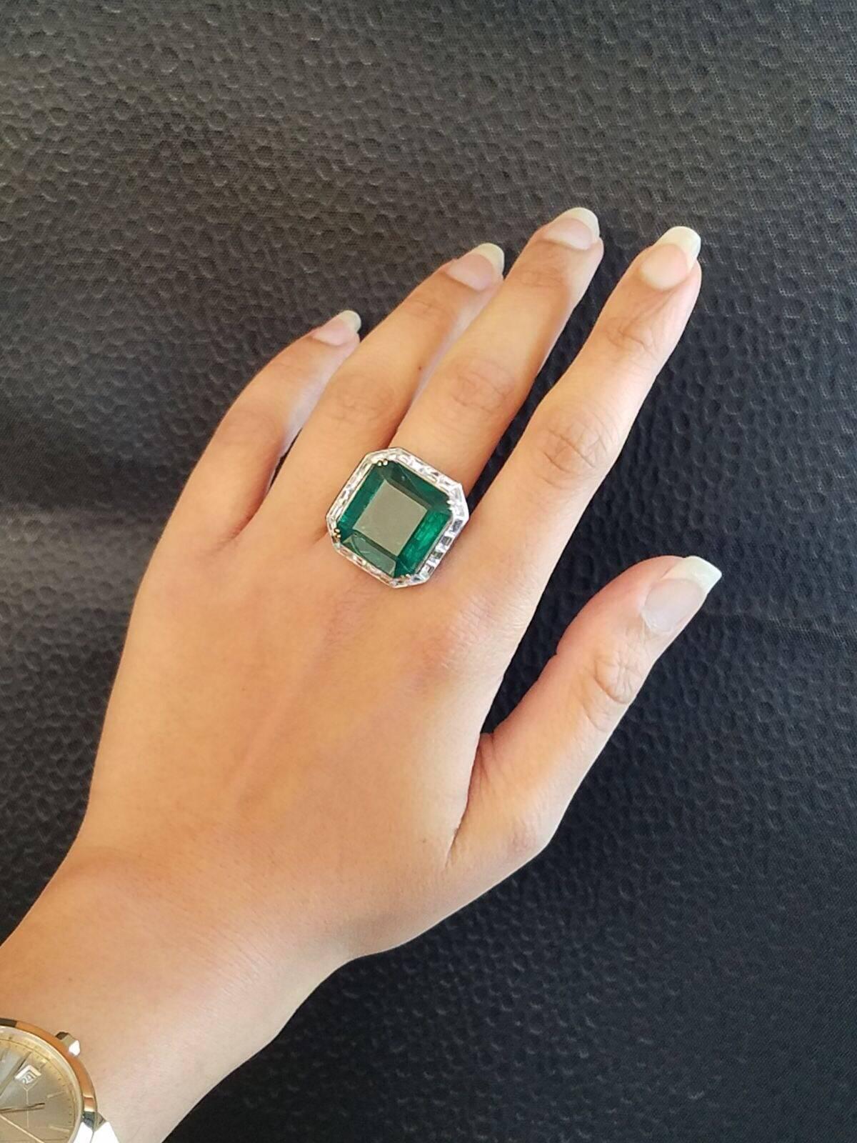 Statement  Zambian Emerald ring surrounded by Diamond baguettes  set on 18K White Gold band.

Centre Stone Details:  
Stone: Emerald
Cut: Emerald
Weight: 24.66 carat

Diamond Details:
Cut: Baguette
Total Carat Weight: 2.27 carat 
Quality: VS/SI ,