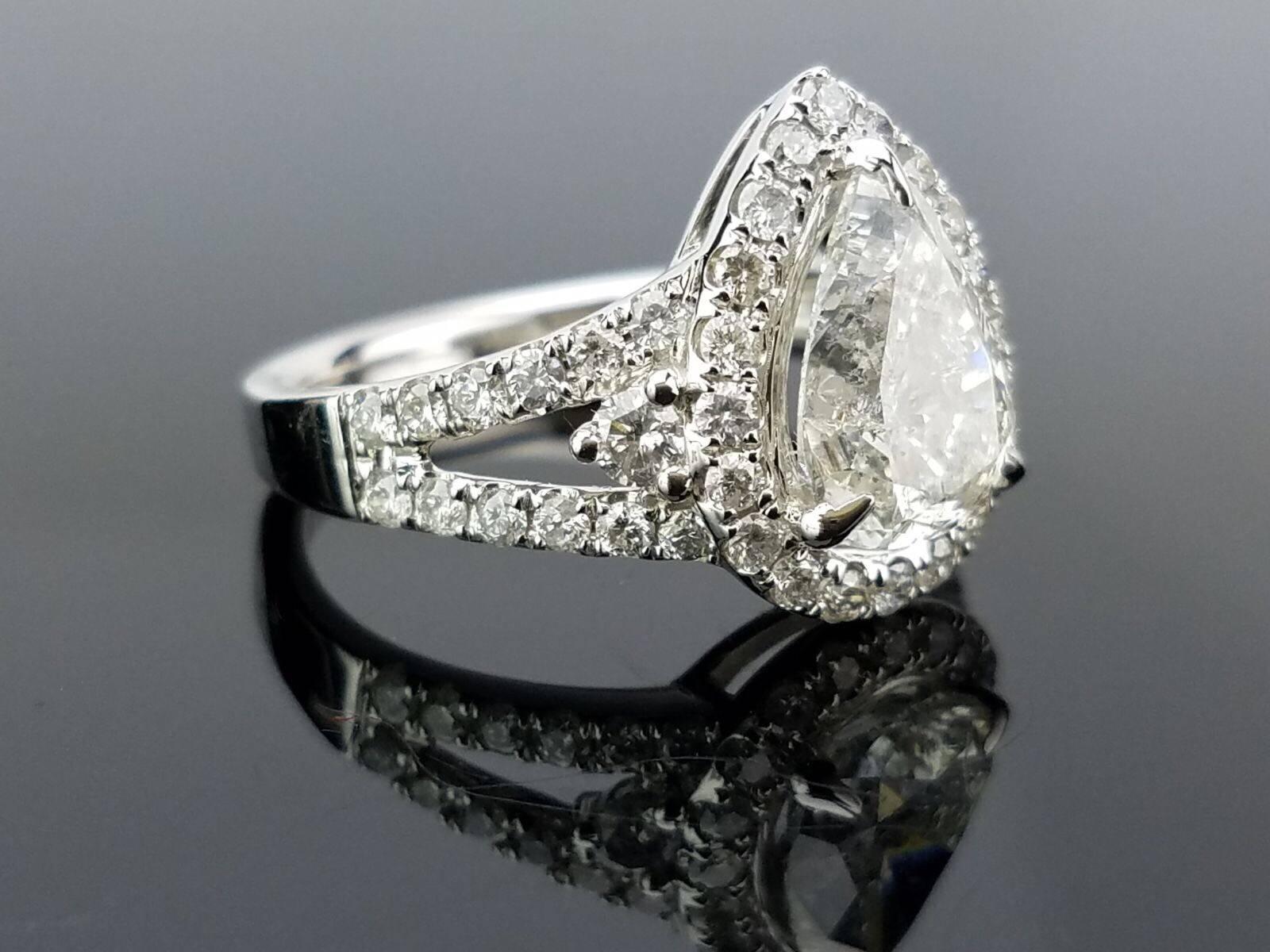 Statement pear shape diamond ring, with half moon side stones. 

Diamond Details: 
Cut: Pear shape
Carat Weight: 2.18 carat 
Quality: I

Cut: Half moon 
Carat Weight: 0.12 carat
Quality: SI/I

Cut: Brilliant (round)
Carat Weight/l 0.70
Quality: