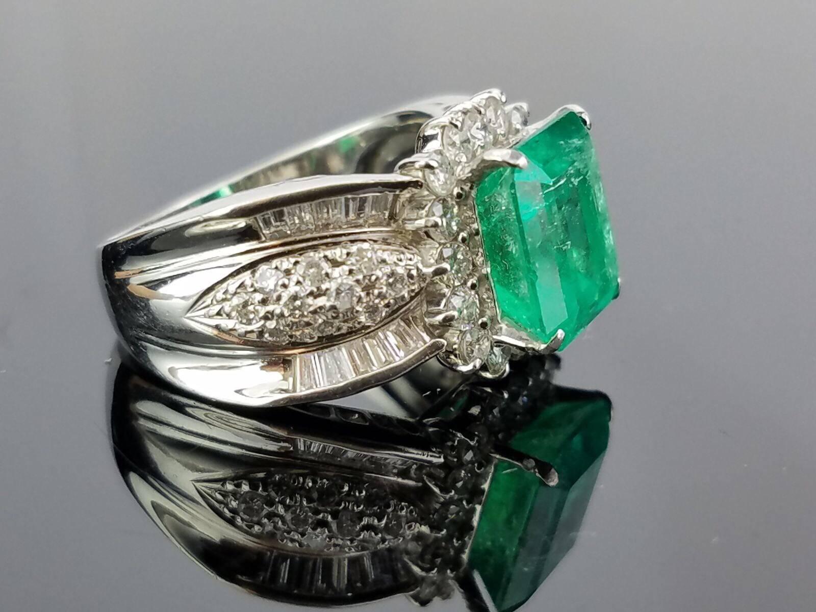 Beautiful Colombian Emerald surrounded by Diamond cocktail ring, all set in Platinum.

Stone Details: 
Stone: Colombian Emerald
Cut: Emerald shape
Carat Weight: 3.31 Carat

Diamond Details:
Cut: Brilliant cut/Baguettes
Total Carat Weight: 1.12