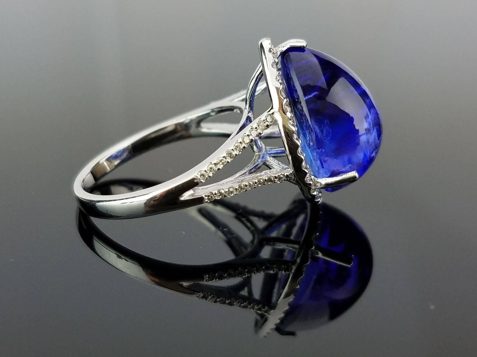 Bague en tanzanite, avec une belle teinte de bleu/pourpre - entourée d'une rangée de diamants. 

Détails de la pierre :  
Pierre : Tanzanite 
Coupe : Cabochon en forme de poire 
Poids en carats : 10,9 carats 

Détails du diamant : 
Coupe : Coupe