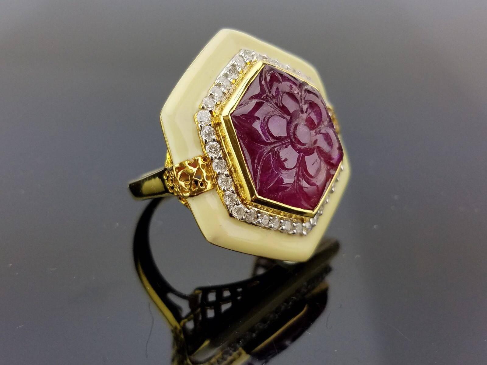 Beautiful, intricitally carved ruby cocktail ring, sorrounded by white diamonds and white enamel - all set in 18K yellow gold. 

Stone Details: 
Stone: Ruby 
Carat Weight: 11.00 Carat

Diamond Details:
Total Carat Weight: 0.58 carat
Quality: VS/SI ,