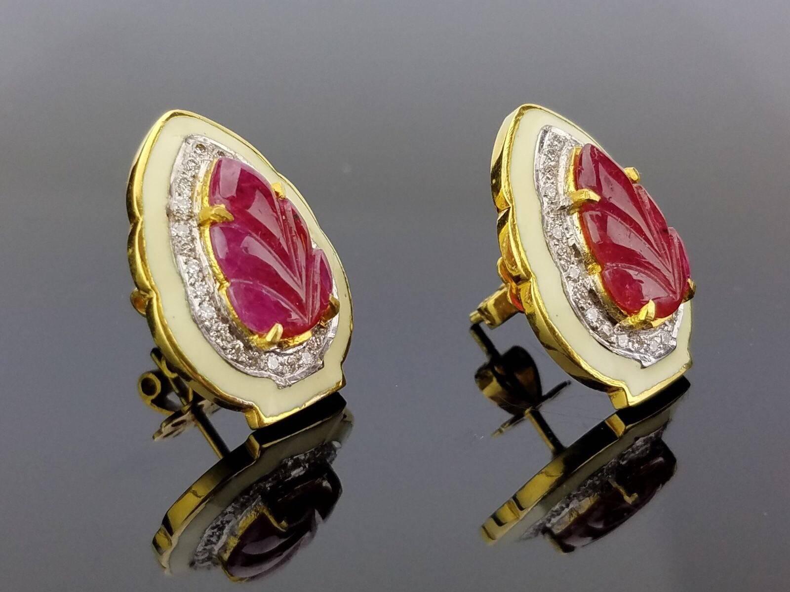 A unique pair of stud earrings, with leaf-shaped carved ruby and white diamonds, outlined with enamel. All set in 18K yellow gold. 

Ruby Weight: 5.23 carats
Diamond Weight: 0.49 carats (VS/SI , H/I) 
Gold Weight: 9.22 grams