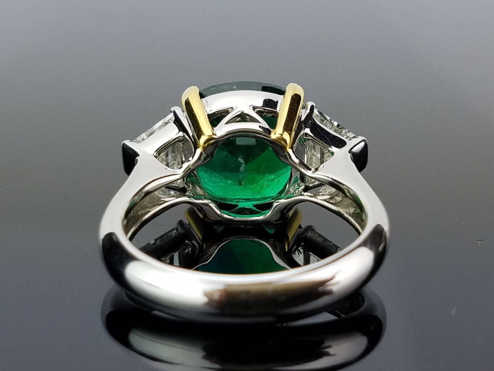 A classic design of a very high-quality, transparent cushion-shaped Zambian Emerald with trapeze White Diamond side stones, all set in 18K white gold. 

Stone Details: 
Stone: Zambian Emerald
Cut: Cushion
Carat Weight: 5.46 Carat

Diamond