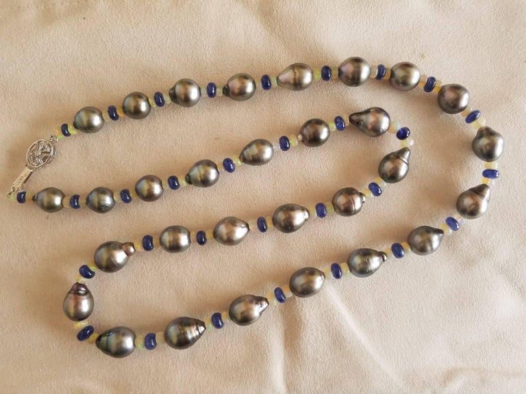 A very elegant and uniquely combined strand of black South Sea pearls, Ethiopian opals and blue sapphire. It comes with a 18K gold clasp studded with diamonds. 