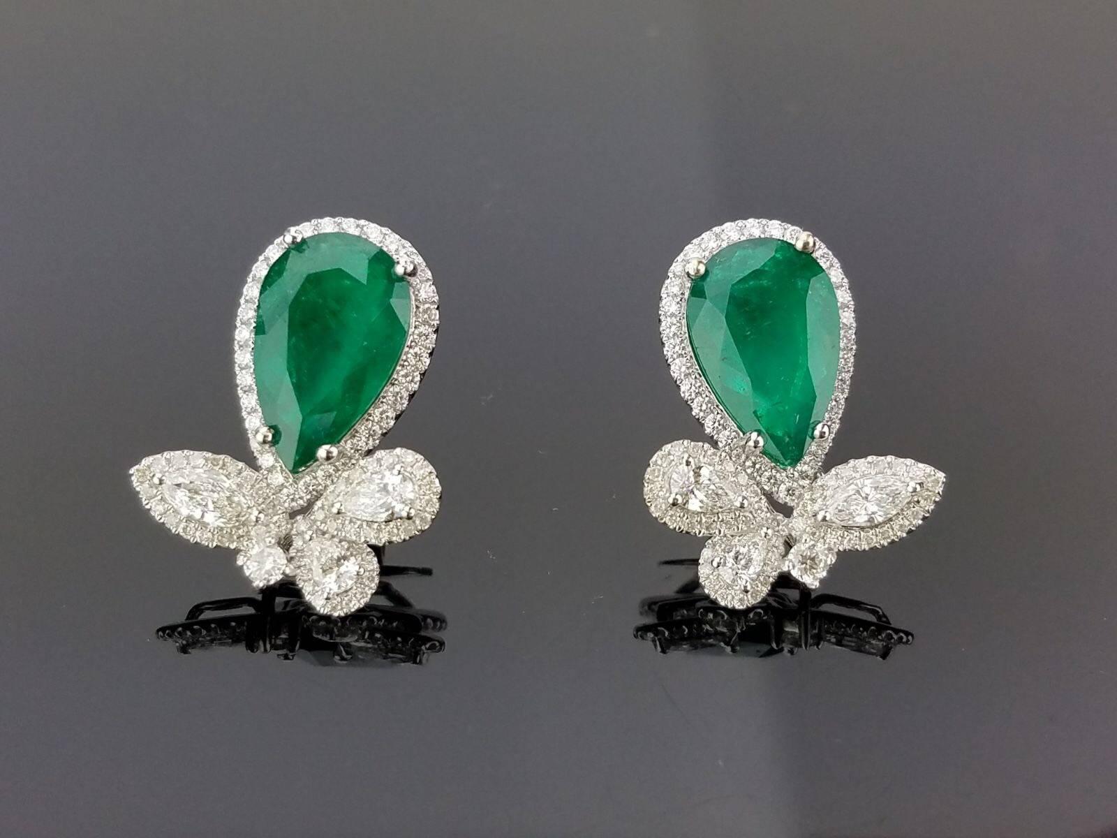 A classic pair of earrings manufactured in Hong Kong, with 4 lustrous pear-shaped Colombian Emeralds surrounded by diamonds and a simple floral looking white diamond mid-section, making it a unique design. The earring has a push and pull backing,