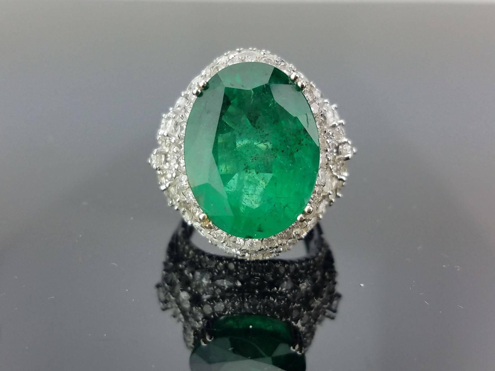 Stone Details: 
Stone: Zambian Emerald
Cut: Oval
Carat Weight: 15.79 Carat

Diamond Details: 
Total Carat Weight: 3.08 carat
Quality: VS/SI , H/I

18K Gold: 16.10 grams 

Currently a ring size US 7, but we can resize the ring for you without added