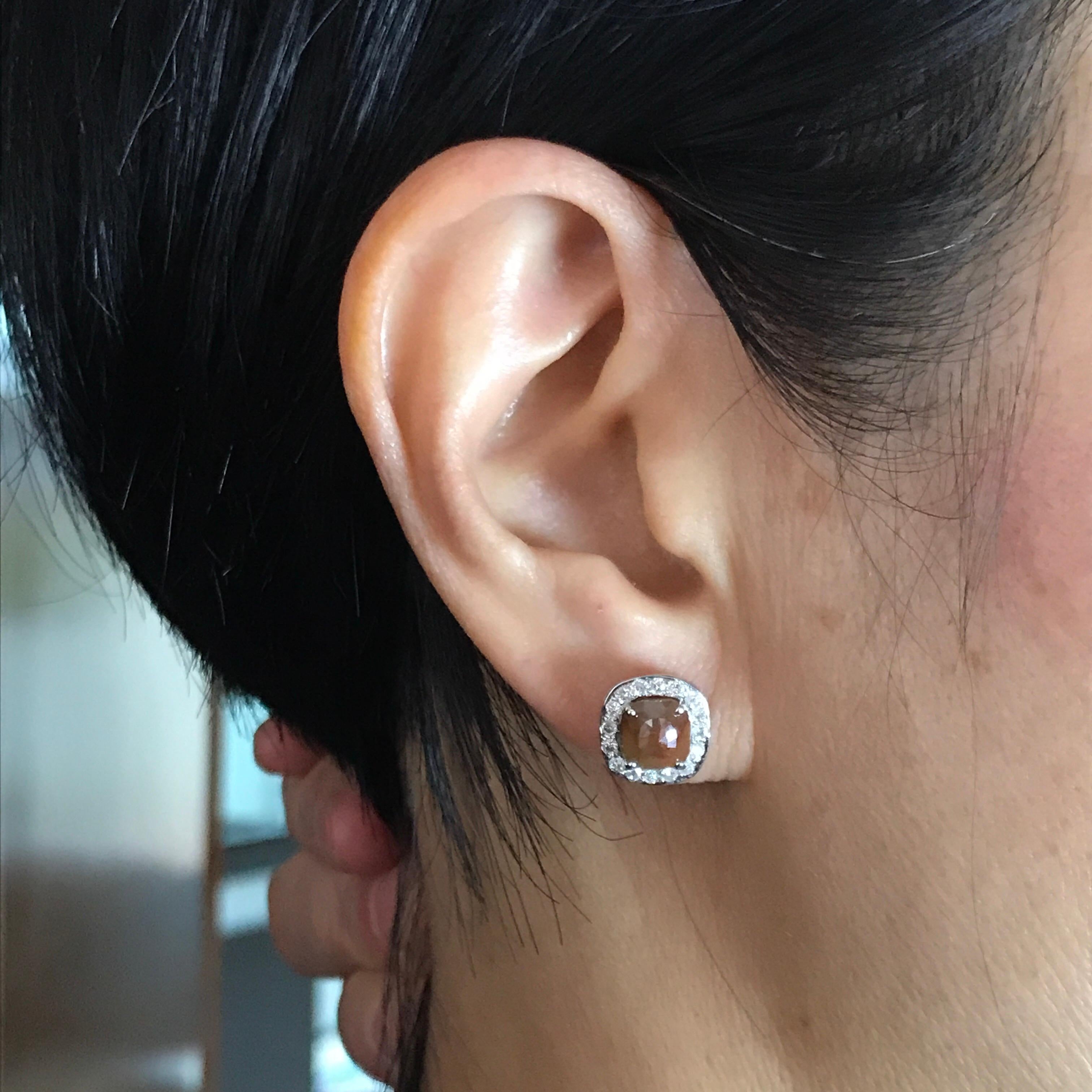 A beautiful pair of simple, and elegant Brown Diamond Earrings surrounded with White diamonds; all set in 18K White Gold. The brown diamonds weigh approximately a carat each. The earrings come with a push back post. 