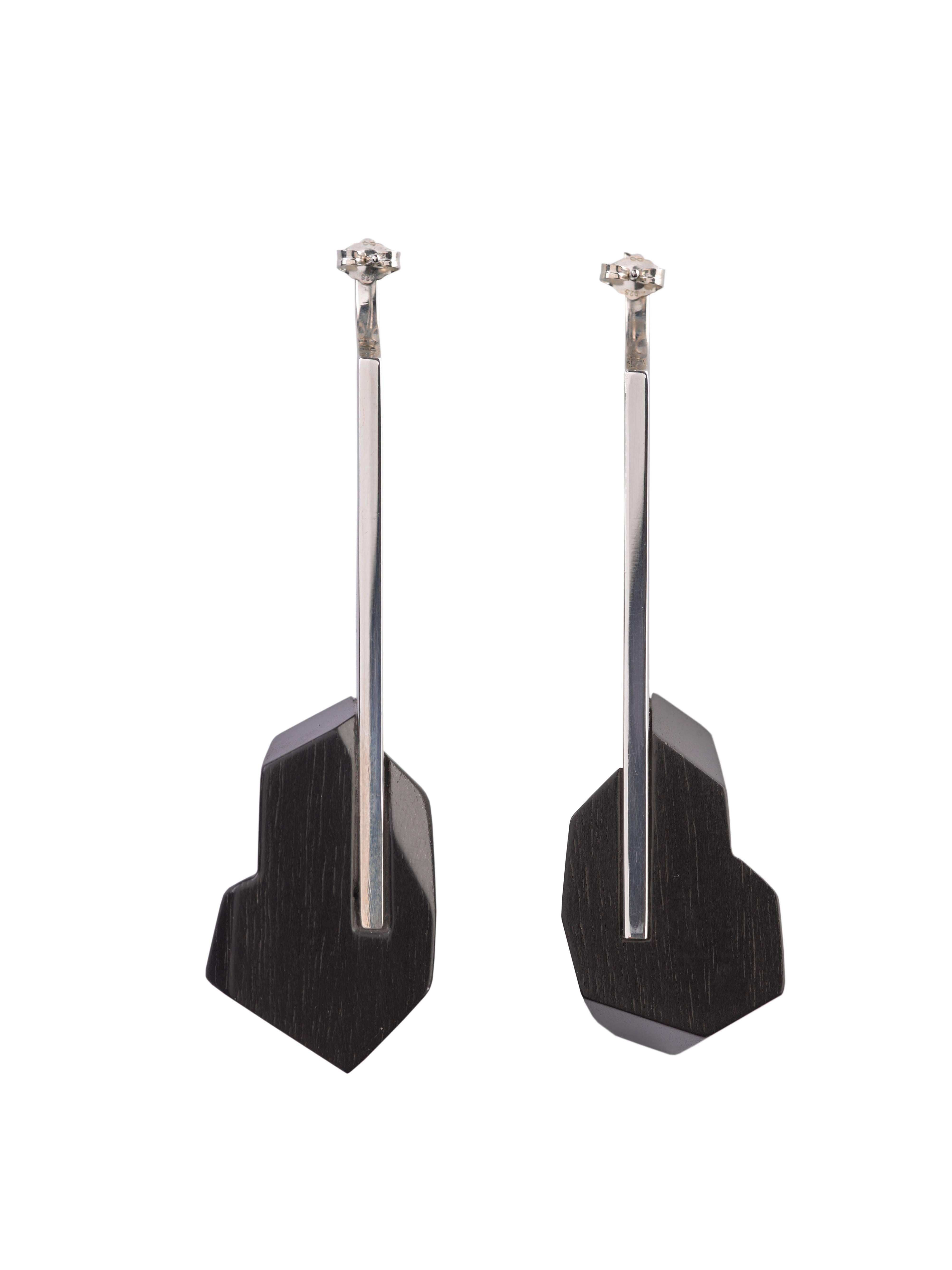 These statement earrings feature faceted hand-carved jet black ebony contrasted with a highly reflective sterling silver bar.  This piece truly encapsulates what modern, elegant jewelry stands for.