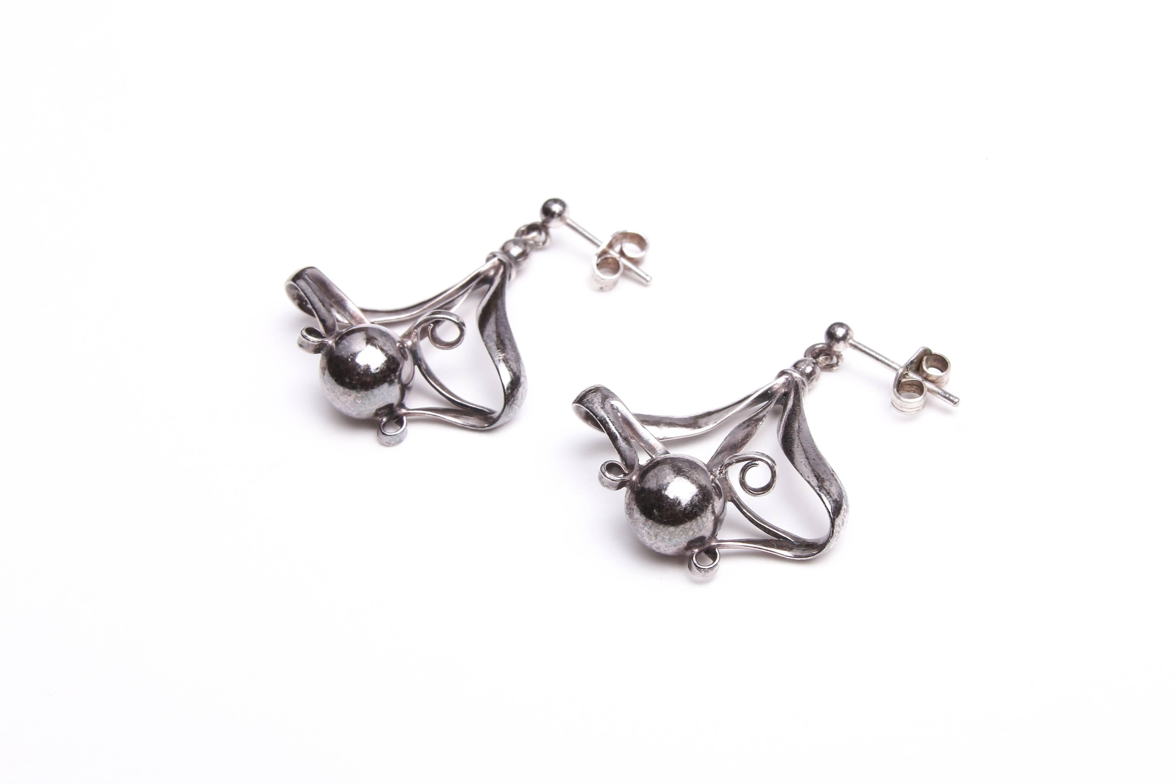 A pair of solid sterling silver antique earrings by Charles Horner in the Art Nouveau style. A rare design, comprising three strands scrolling down to a solid ball, creating a three-dimensional shape. Hallmarked. Stud fasteners with backs for