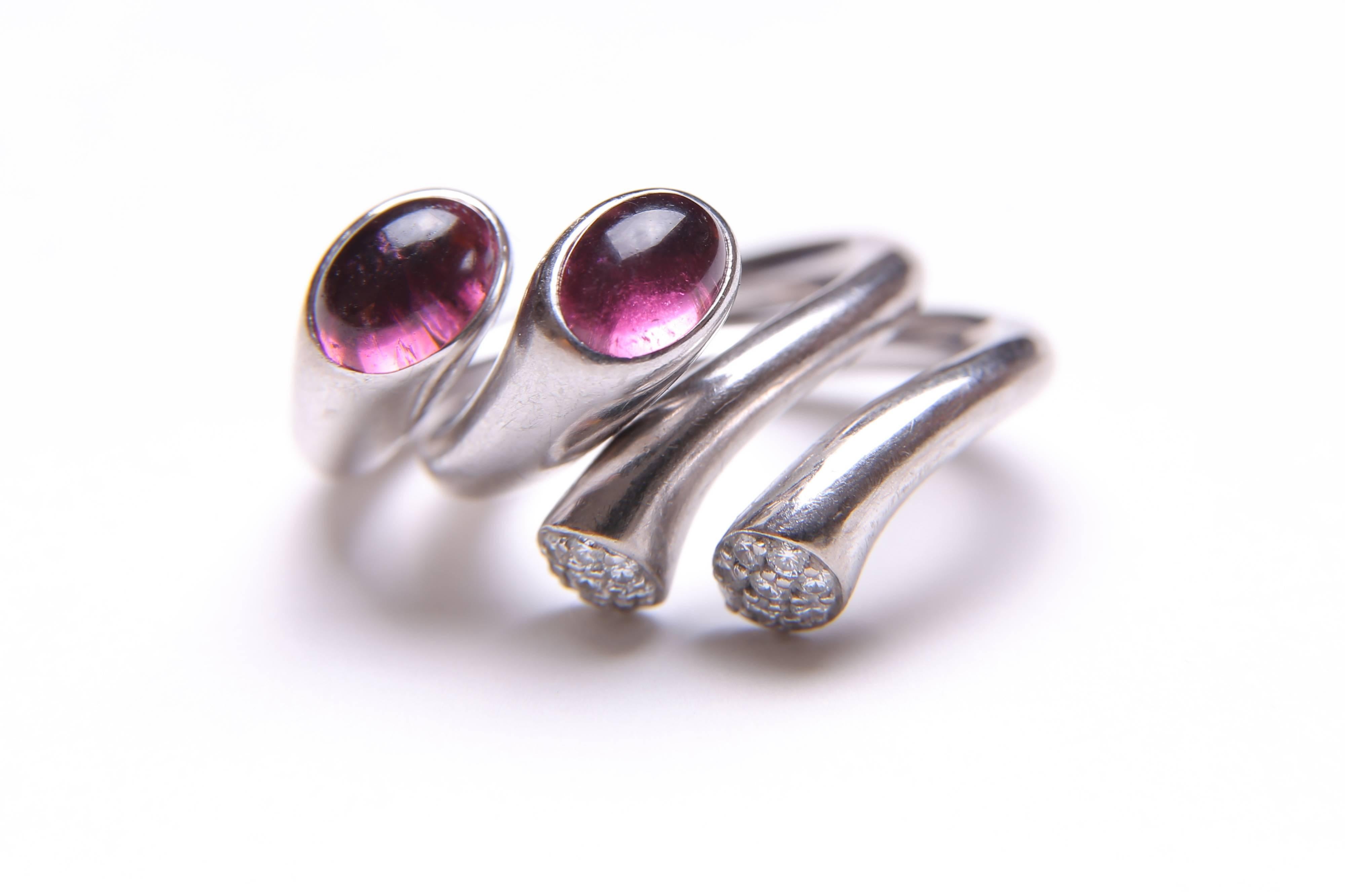 Georg Jensen - two white gold diamond and tourmaline Carnival rings. The designer is Regitze Overgaard. Each is designed as an open band, with oval pink tourmaline cabochon and pave-set diamond asymmetrical terminals. Each stamped 750 and with the