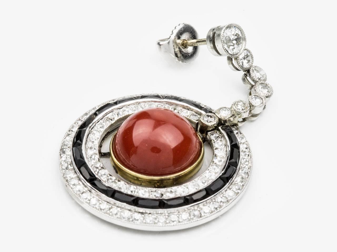 Platinum earpendants centering Coral cabochon with diamond and onyx bezels. Approximate diamond weight is 4.50 carats.