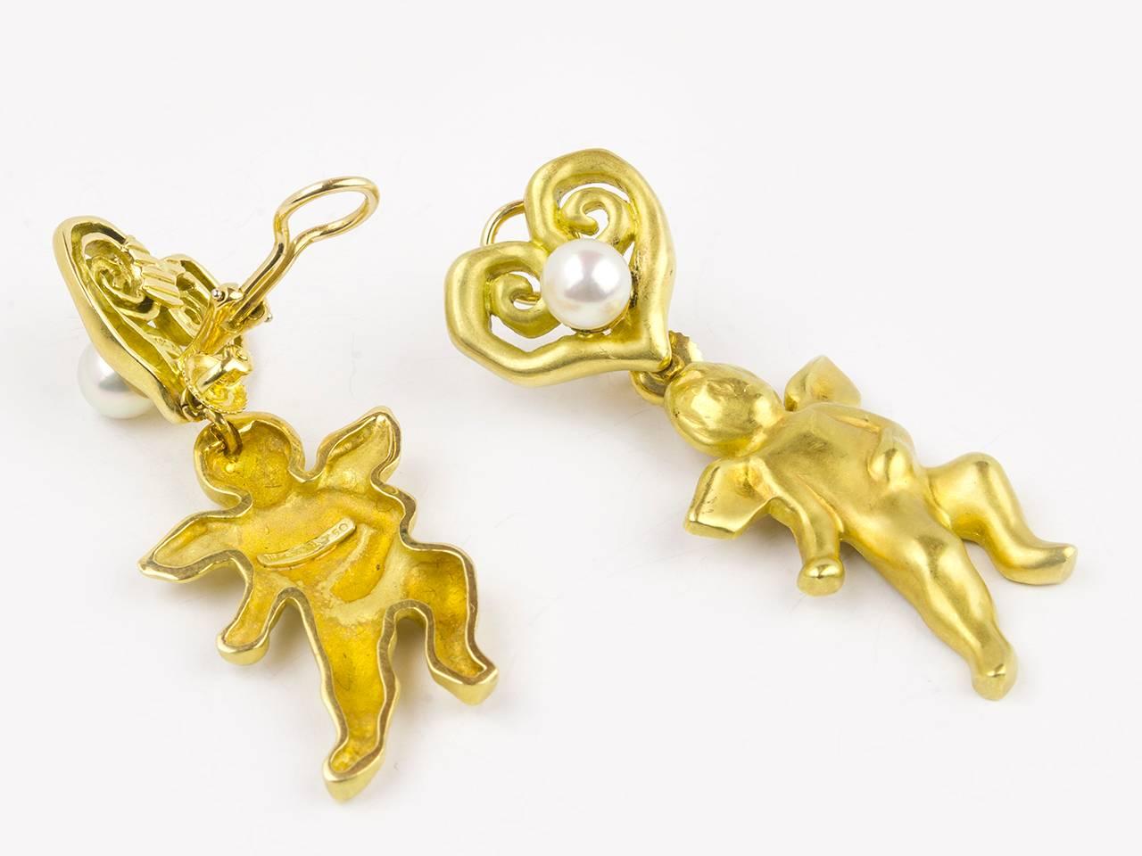 18k  heart- shaped pearl earclips suspending gold cherubs.. Signed TIFFANY & Co.