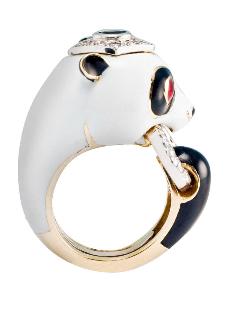 18kt. gold ring in form of a Panda Bear in white and black enamel set with ruby eyes , sapphire and diamond cap and diamond connecting ring. Signed WEBB.