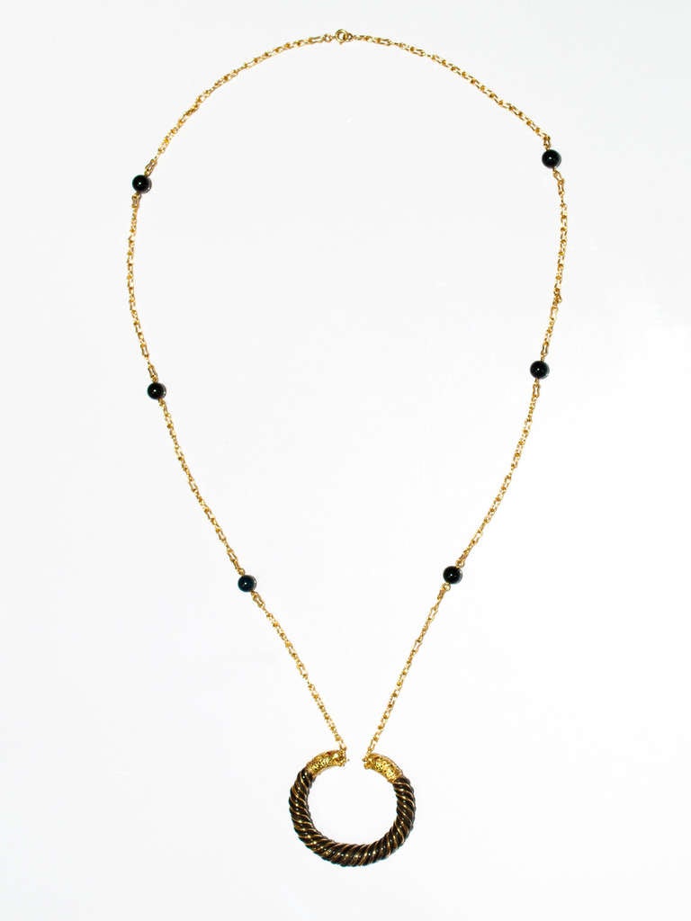 18 kt.gold chain set with onyx beads, suspending  a gold and elephant hair pendant with stylized leopard terminals., with ruby eyes . French hallmarks and maker's mark for Gay Freres.