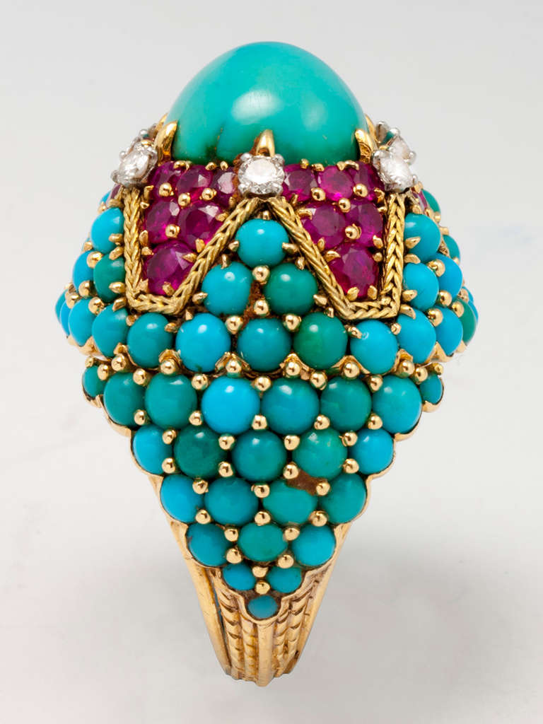 ring aus 18 Karat Gelbgold mit einem ovalen Türkis im Cabochon-Schliff:: sechs runden Diamanten im Brillantschliff:: 36 Rubinen im Mischschliff
und zahlreichen runden Türkisen im Cabochon-Schliff. Handbeschriftung MARCHAK PARIS 33396.