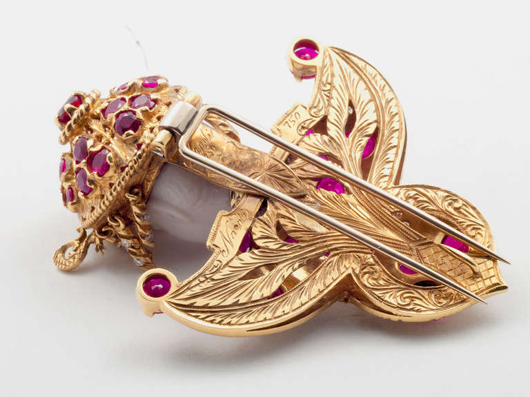 18 kt. gold clip depicting the Princess Turandot from Puccini's opera. The clip features a carved chalcedony head with elaborate openwork headdress, set with 11 movable tassels set with diamonds and rubles. Total ruby weight 8.50 carats