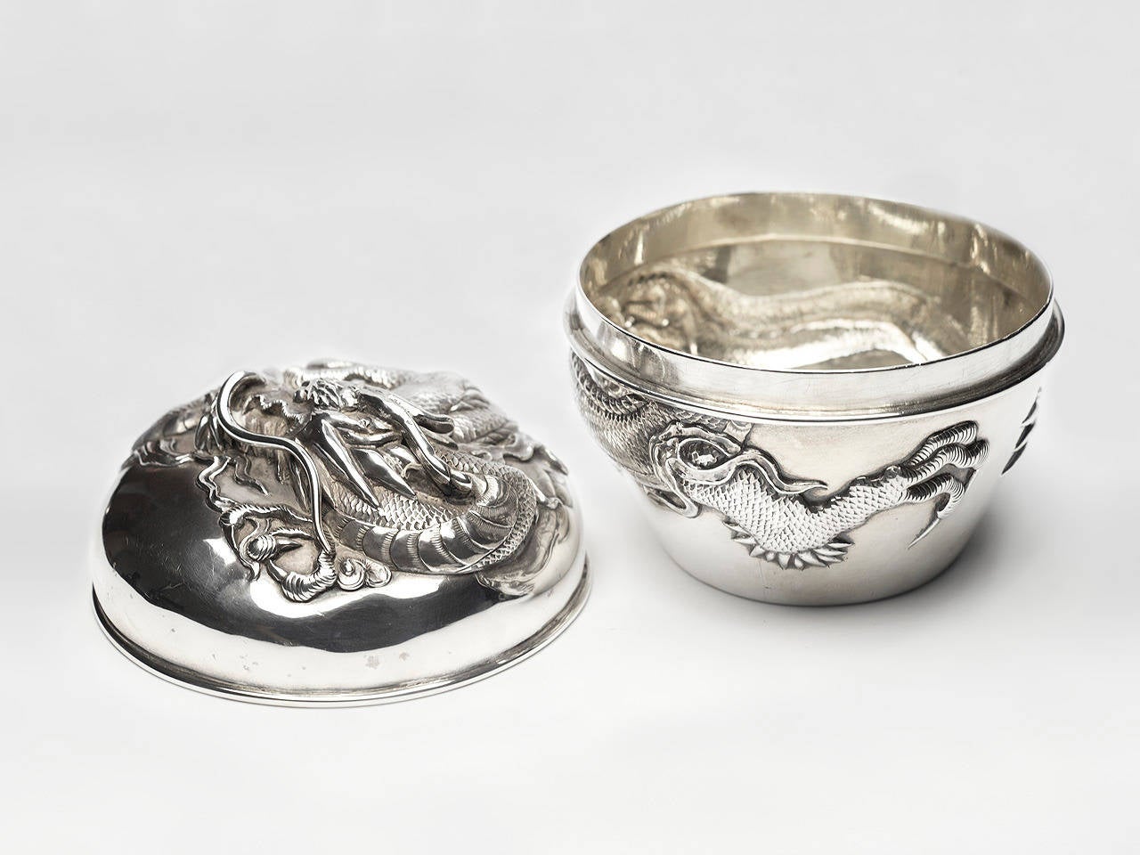 Antique Chines Export silver lidded box in a high relief dragon motif. Maker's mark for Luan Hing and export marks.