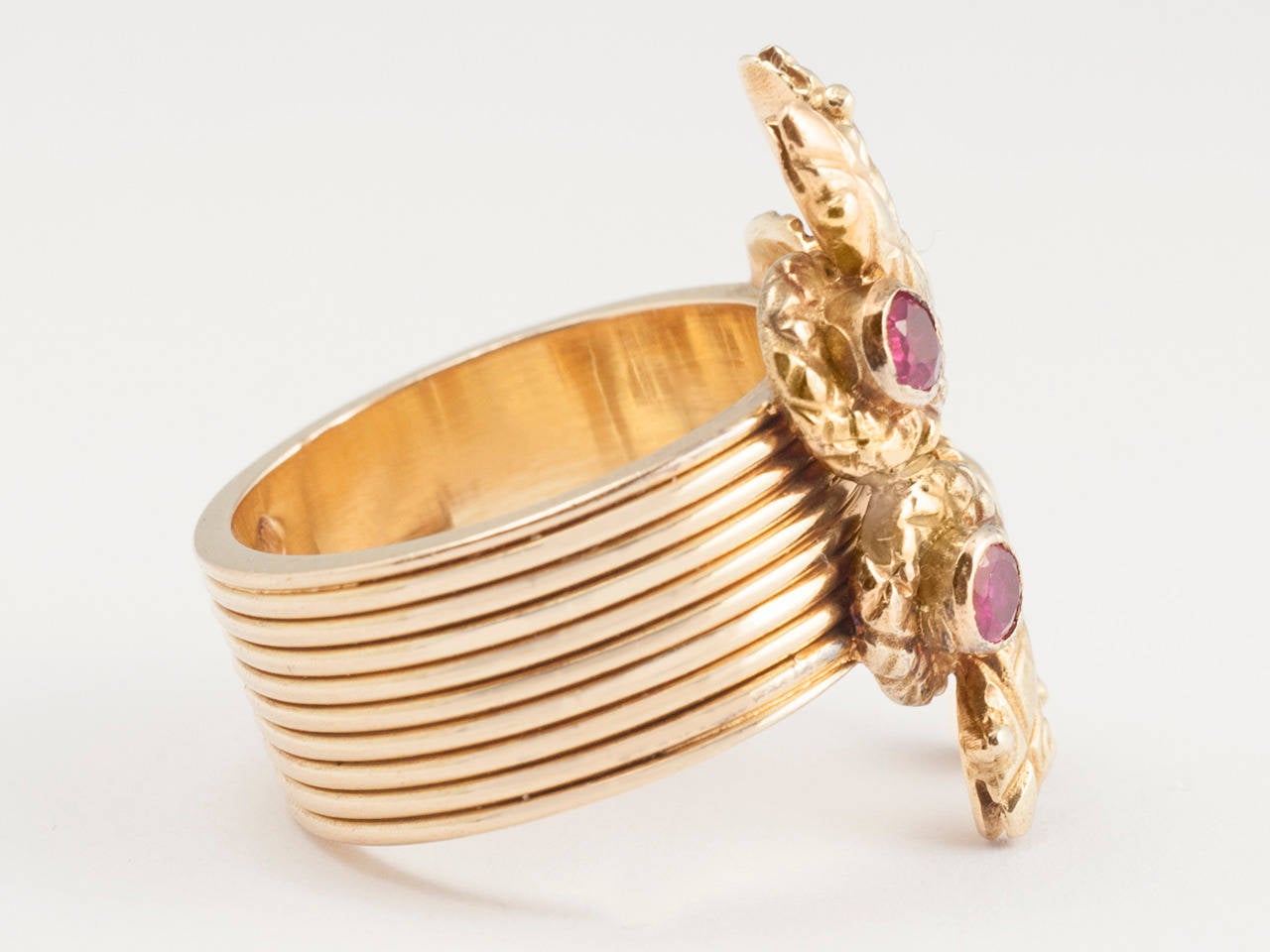 18 kt. Gold ring with fluted shank, centering 4 coiled snakes with cabochon ruby heads. signed.