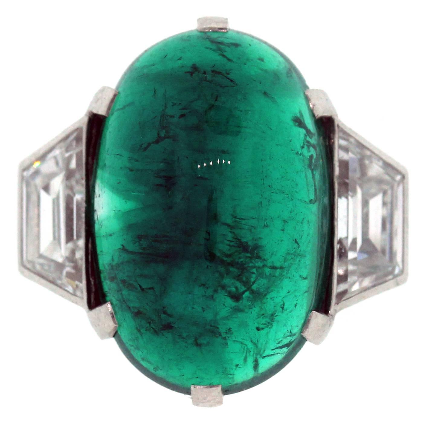 Colombian Emerald and Trapezoid Diamond Platinum Ring by Tiffany & Co. 

Center Emerald is a gorgeous Cabochon-cut, Oval, Colombian Emerald apprx. 15ct. AGL Certified (Certification in photos). 

Ring is done in Platinum and the trapezoid diamonds