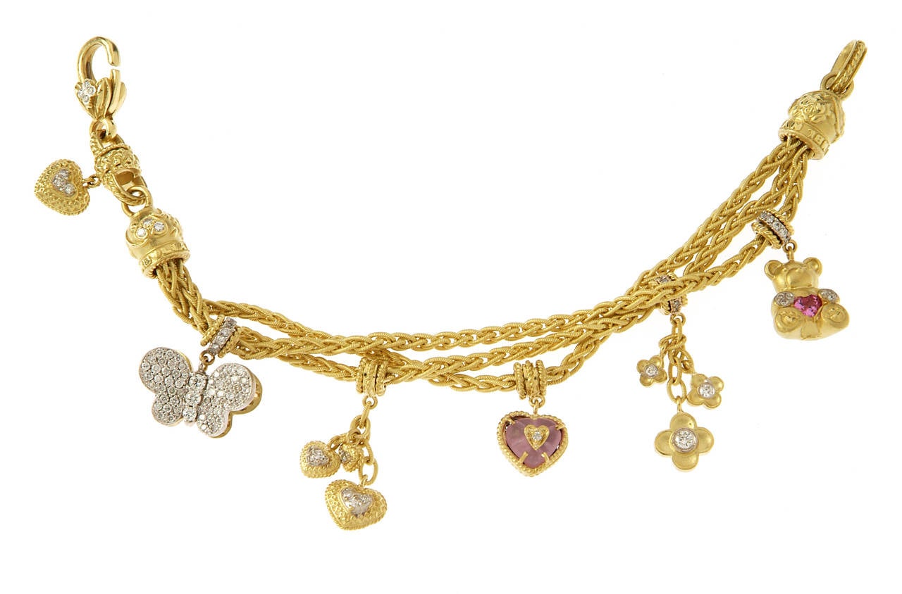 One of a kind charm bracelet by Stambolian.

18k Gold & Diamond (2.10 ct.'s)

Charm 1: Butterfly: One side is Pave set with White Diamonds, on the other side is Pave set yellow diamonds.

Charm 2: Double sided diamond hearts

Charm 3: Double
