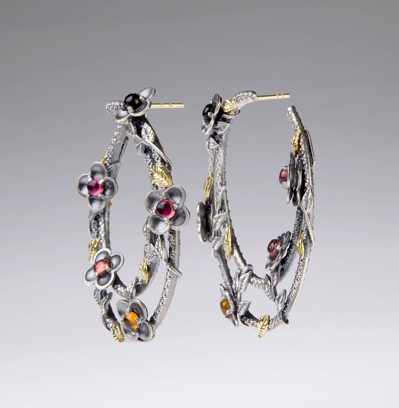 Aged Silver & 18K Gold Hoop Earrings With Multi-Color Tourmalines by Stambolian

2 carat's of Multi-Color 

Earrings are side-hoops and are slightly slanted for a stunning look. They dress beautifully and have gorgeous gold leaves placed around the
