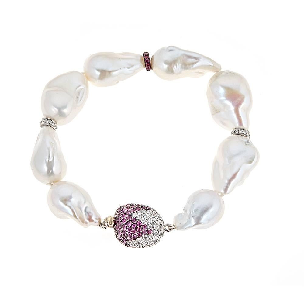 Featuring magnificent Baroque White South Sea Pearls, this bracelet revitalizes a classic with 2.94 carats of Deep Pink Sapphires, 0.10 carats of Rubies and 2.21 carats of round white Diamonds, set in 18K White Gold.

Features: Color variations