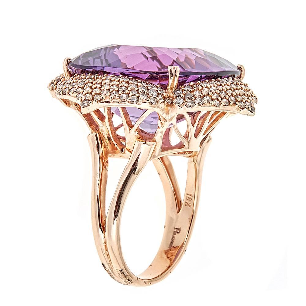 A dynamic, florally inspired, cocktail ring featuring a 25.89 carat cushion Amethyst. Surrounding the center Amethyst are four leaves of 18k Rose Gold set with 1.50 carats of bright Champagne Diamonds.

Size: 5.75
Total Weight: 14.67g
