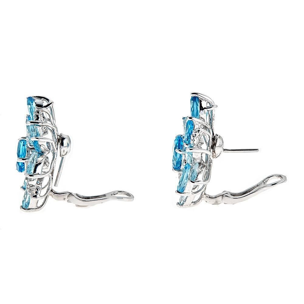 Magnificent, floral 18K White Gold earrings designed with a combined 25.74 carats of oval, pear and marquise cut Blue Topaz. The brightly colored topaz is softly accented by 0.35 carats of round Diamonds. 

Features: Bendable Post Clip Back
Total