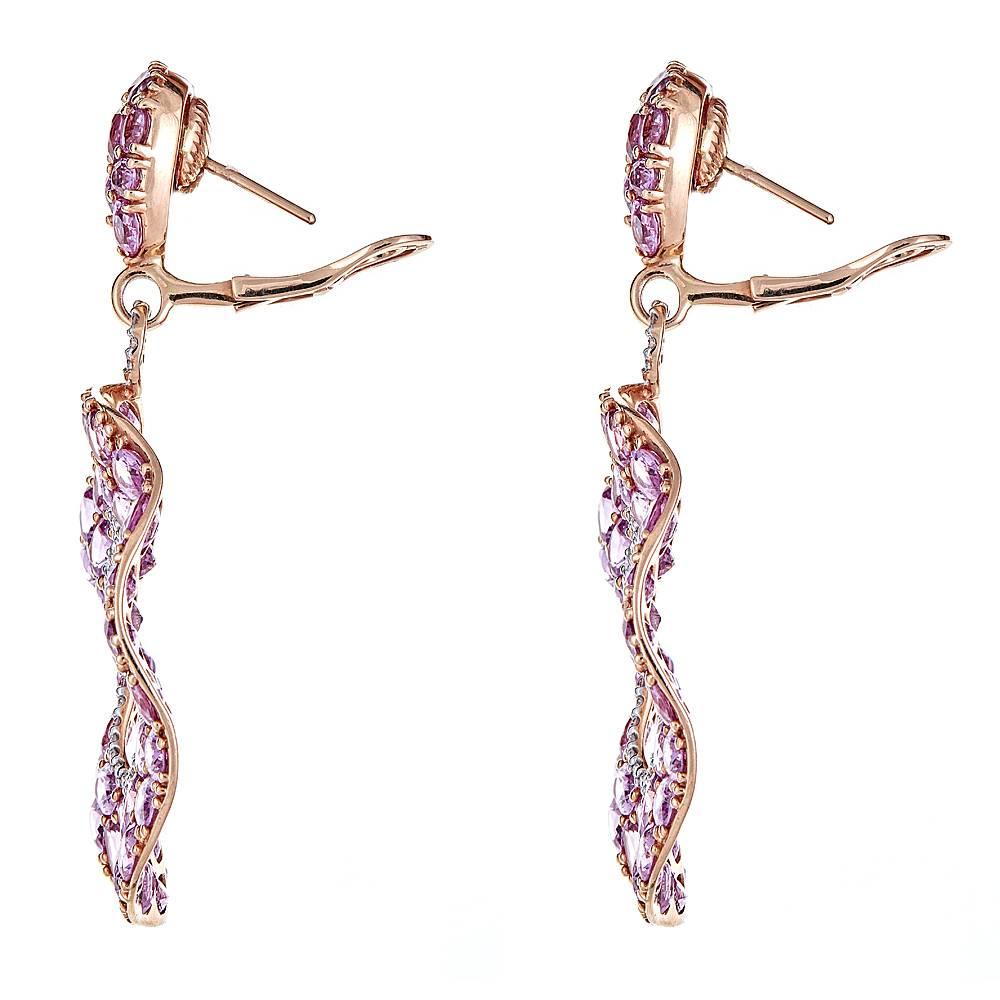 Unique drop earrings that can seamlessly transition from day to evening wear. With 51.03 carats of vivid, oval Pink Sapphires set in 18K Rose Gold and 1.08 carats of accentuating round Diamonds set in 18K White Gold, these earrings are one of a kind
