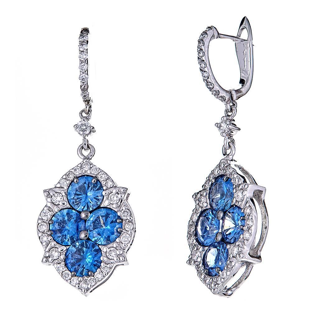 4.06 carats of Blue Sapphires set in 18K White Gold. With a pave diamond drop clasp and 0.85 combined carats of round Diamonds, these earrings add a burst of color to a classic style. 