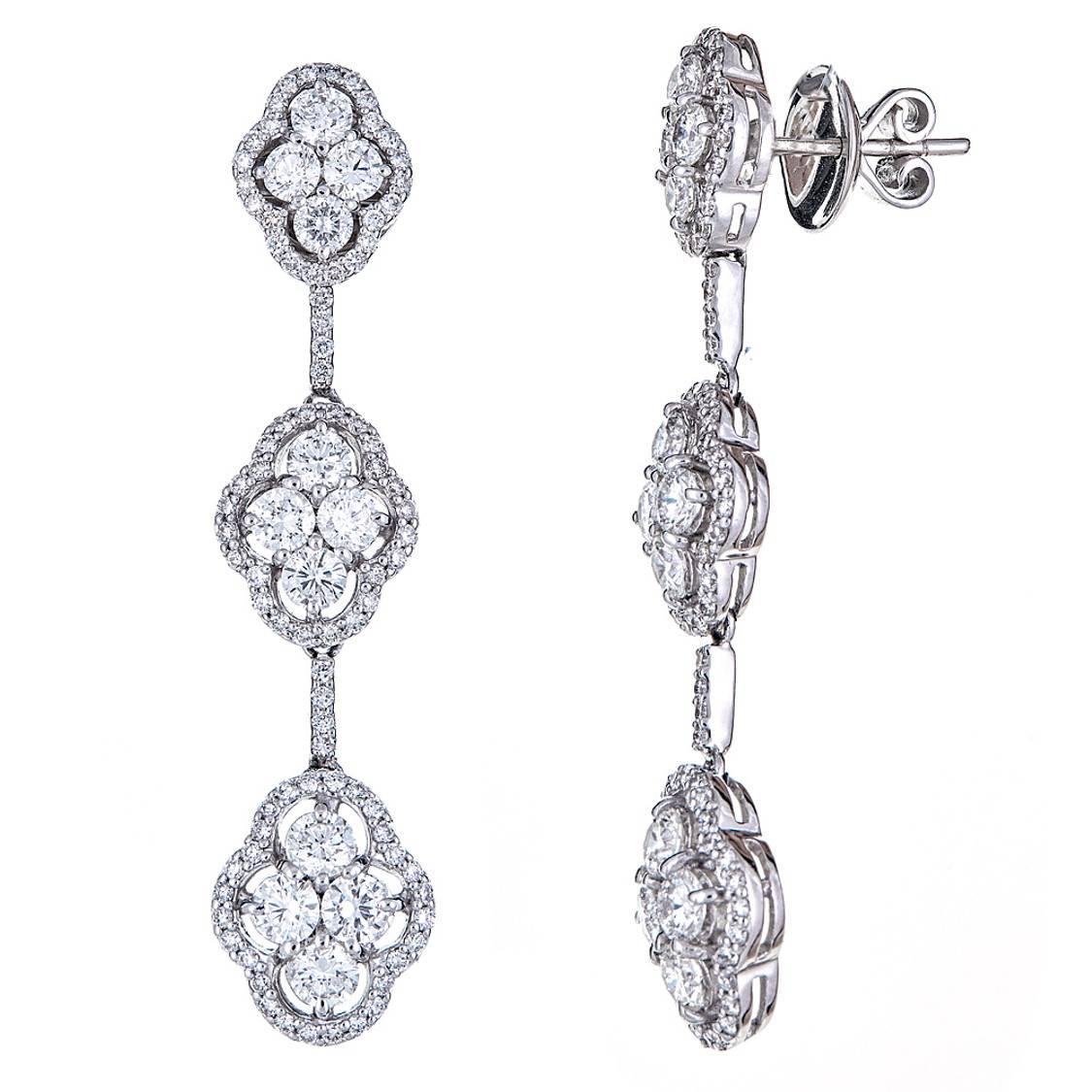 Three delicately tiered, diamond cluster earrings with 4.70 carats of round white Diamonds. Set in 18K White Gold, each tier holds four larger diamond stones surrounded by pave diamonds for effortless, minimalistic glamour. 

Features: Post