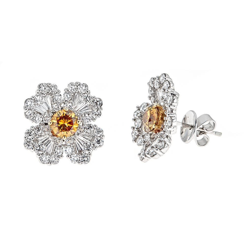 An intricately designed pair of 18K White Gold stud earrings. These floral inspired earrings feature 2.47 carats of round and baguette Diamonds in the shape of four delicate petals. The center stones are 1.08 carats of uniquely colored brown