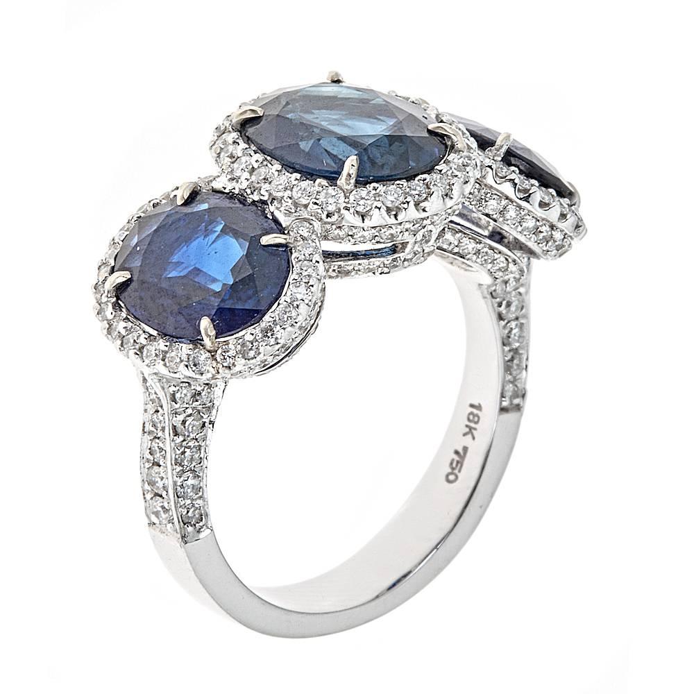Highlighting 8.50 carats of oval Blue Sapphire, this gorgeous three stone ring is easily transitioned between day and evening wear. Surrounding each Sapphire, and intricately incorporated into the band, are 0.92 carats of accenting round Diamonds.