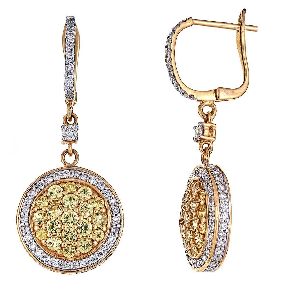 Featuring 1.80 carats of vivid Yellow Sapphires surrounded by numerous brilliant Diamonds, these drop earrings are perfect go-to pieces for all occasions. Set in 18K Yellow Gold, each circle of bold center stones is haloed by a ring of white