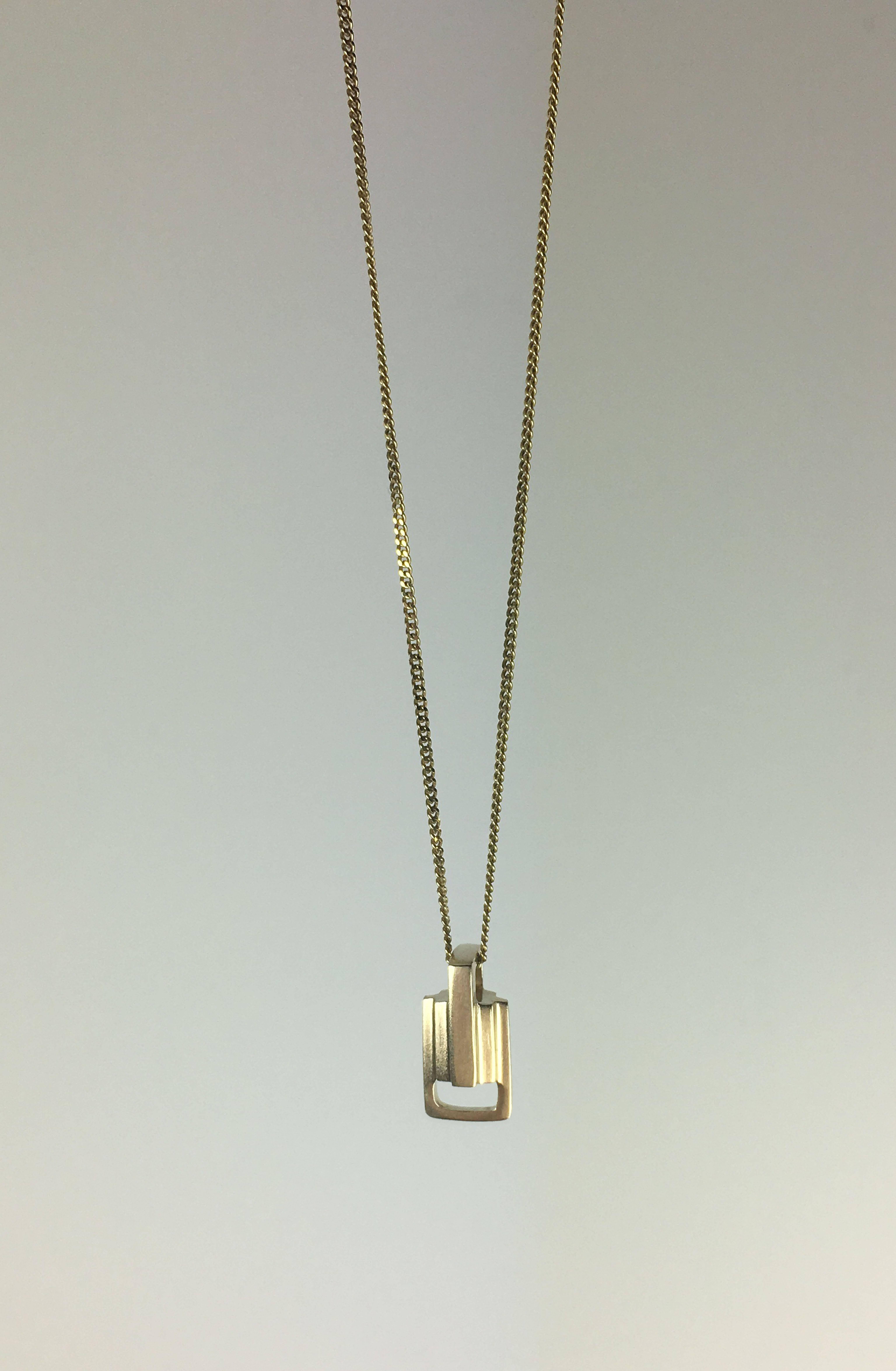 Influenced by the Art Deco style, this elegant 18 karat gold link pendant is classy, architectural and angular. With the steps design, its beauty is in the detail. On an elegant 18 inch gold chain.

Designed and created in Dublin, Ireland. Handling