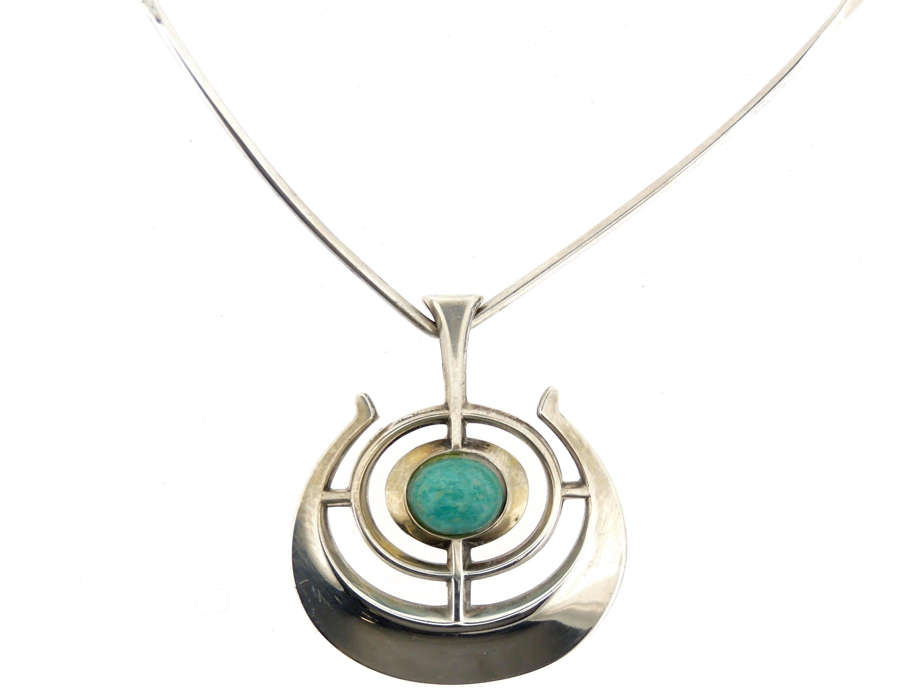 The Ship of Good Fortune pendant and neck ring in sterling silver with a central amazonite cabochon. 

Designed by Bjorn Sigurd Ostern for David Andersen in the 1964, the pendant is in the form of a stylized viking ship. 

This Ship of Good Fortune