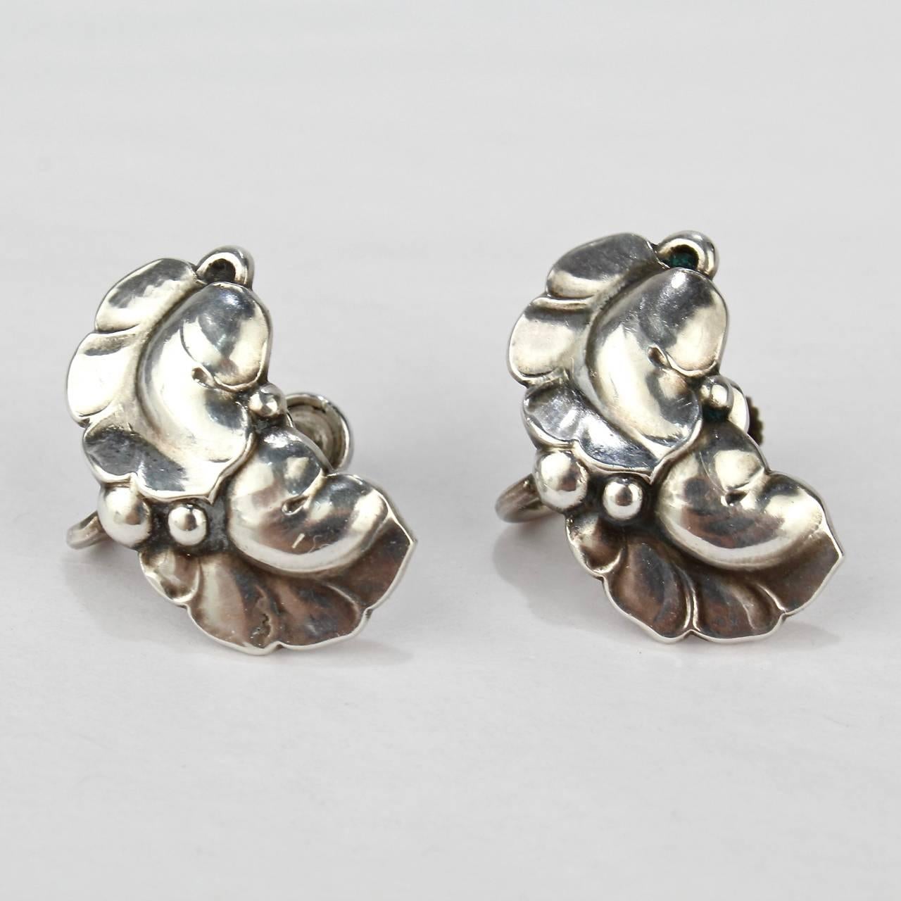 A fine, mid-20th century pair of Georg Jensen Leaf & Berry screw back earrings. 

Designed by Harald Nielsen.

Model no. 50A

Reverse marked: Sterling Denmark Georg Jensen 50A.

Measurements:   
    Length: ca 7/8 in.
    Width: ca. 1/2 in.

Items