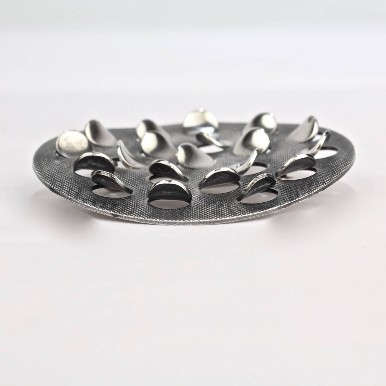 A modernist Norwegian sterling silver Scales or Punkter Pin by Grete Prytz Kittelsen for J. Tostrup.

Grete Prytz Kittelsen was a major figure in the Scandinavian Design Movement. Her goldsmithing and design works earned her acclaim, important