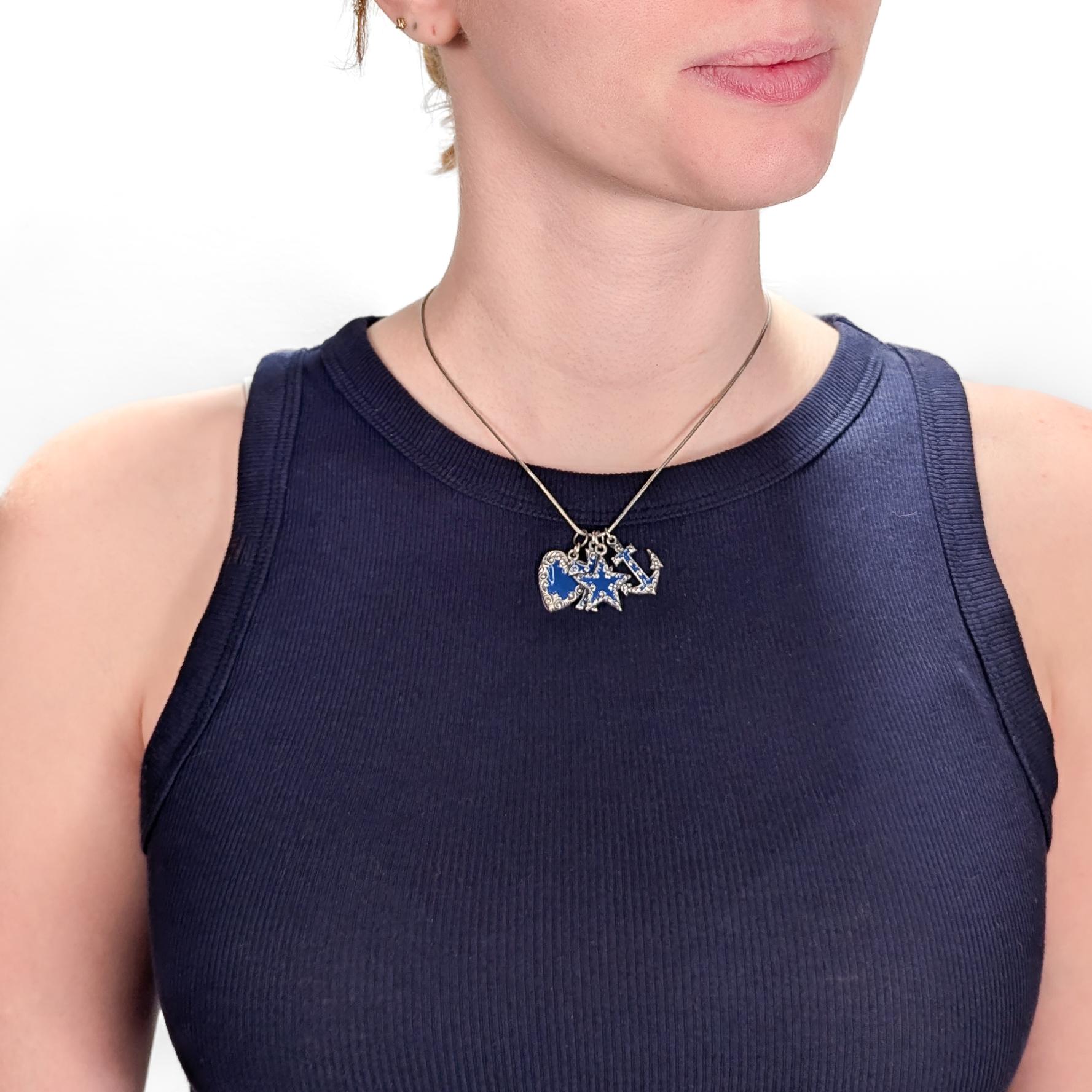 Un raffinato set di 4 ciondoli in argento e smalto.

In argento sterling.

Ognuno di essi ha un corpo in argento sterling con smalto blu cobalto al centro. 

È composto da quattro forme distinte: un cuore, una stella, un'ancora e una croce.